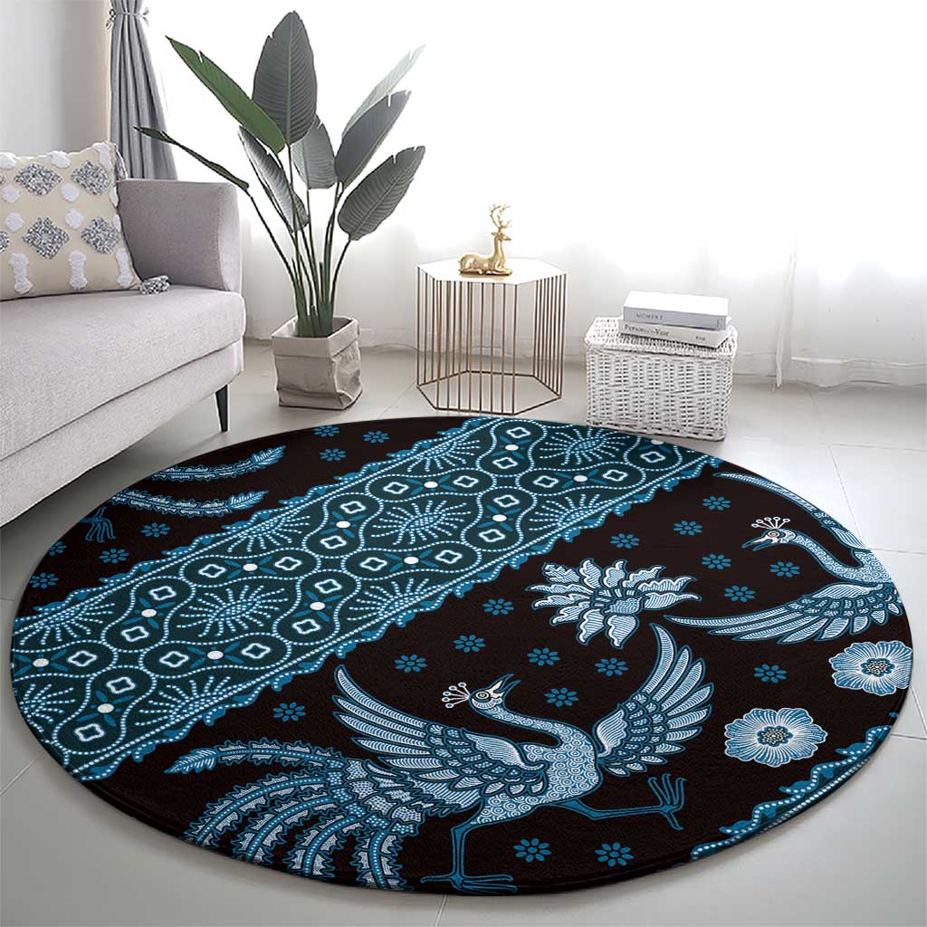 Round area rug with blue batik bird, rosette flowers, and dotted geometric borders
