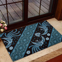 Blue batik pattern rubber doormat with peacock motifs and repeating borders, on entry step