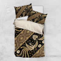 Batik bedding set laid flat with dark duvet cover and gold batik pattern, two pillowcases