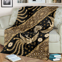 Batik throw blanket on couch arm, dark with gold ornamental bird and medallion design