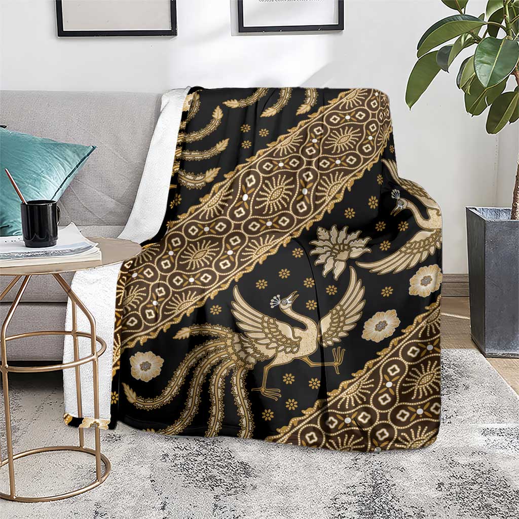 Batik throw blanket over chair, dark fabric with gold bird, floral, and geometric motifs