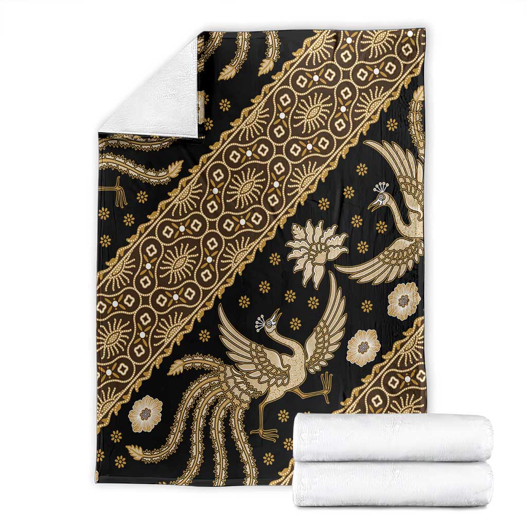 Folded batik throw blanket with rolled towels, dark with gold ornate bird pattern