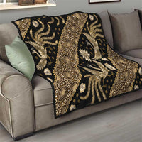 Batik-style quilt throw with gold and cream ornate animal motifs on dark fabric over sofa
