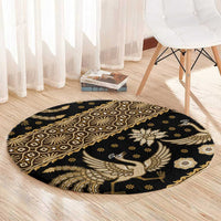 Round batik pattern carpet, dark with gold bird winged emblem and geometric border