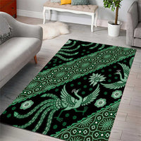 Green batik-style area rug featuring bird centerpiece and geometric border