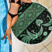 Round green batik-pattern beach blanket with white fringed edge, peacock bird design