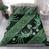 Green batik patterned bedding set with duvet cover and two pillowcases on a bed.