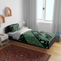 Green batik patterned bedding set with duvet cover and pillowcases in a bedroom setup.