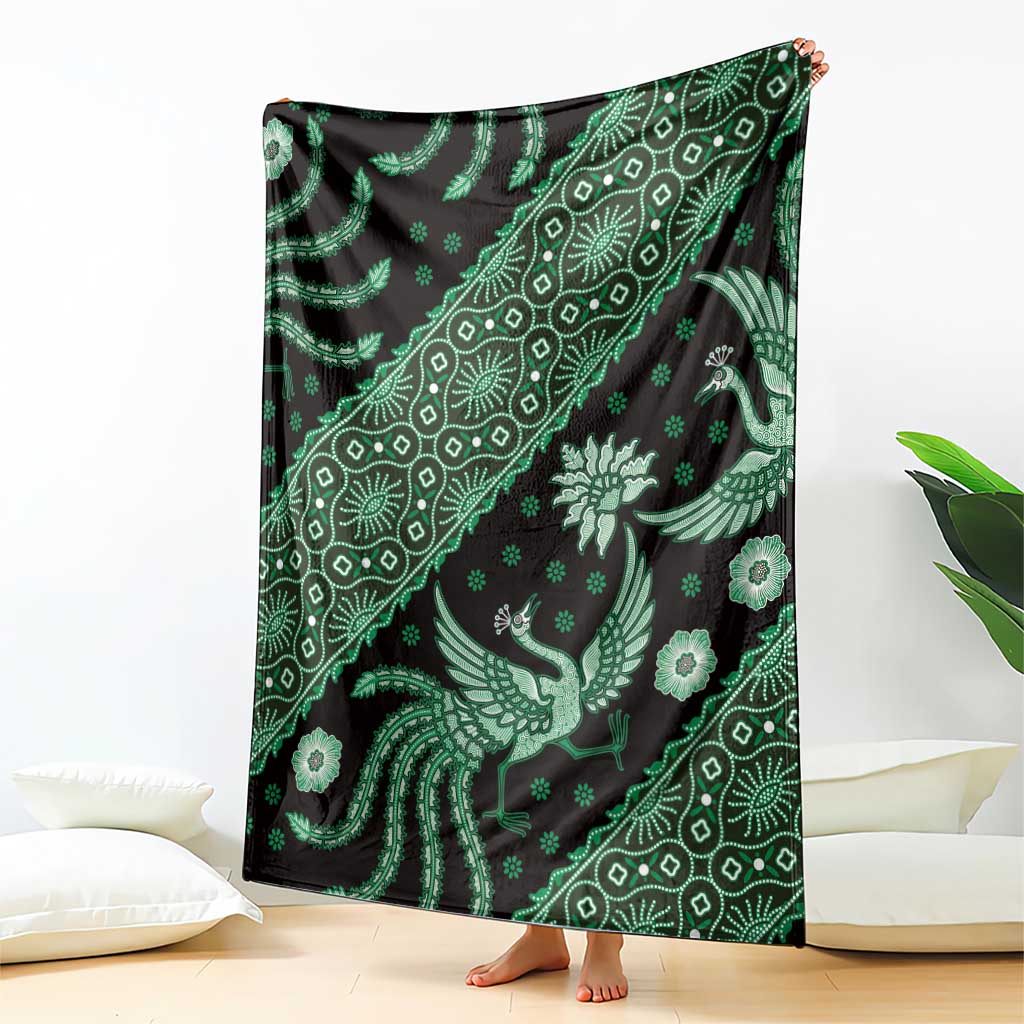Green batik pattern blanket with bird and floral motifs, upright draped view