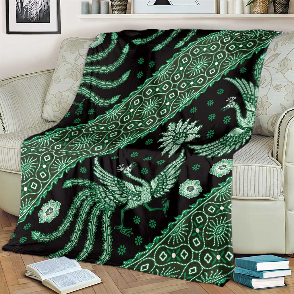 Green batik pattern throw blanket on cream sofa, bird and floral motifs