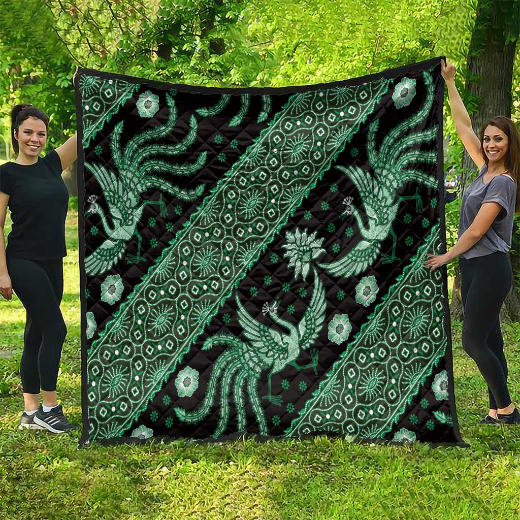 Green and black batik quilt with paisley, floral, and bird motifs; folded square