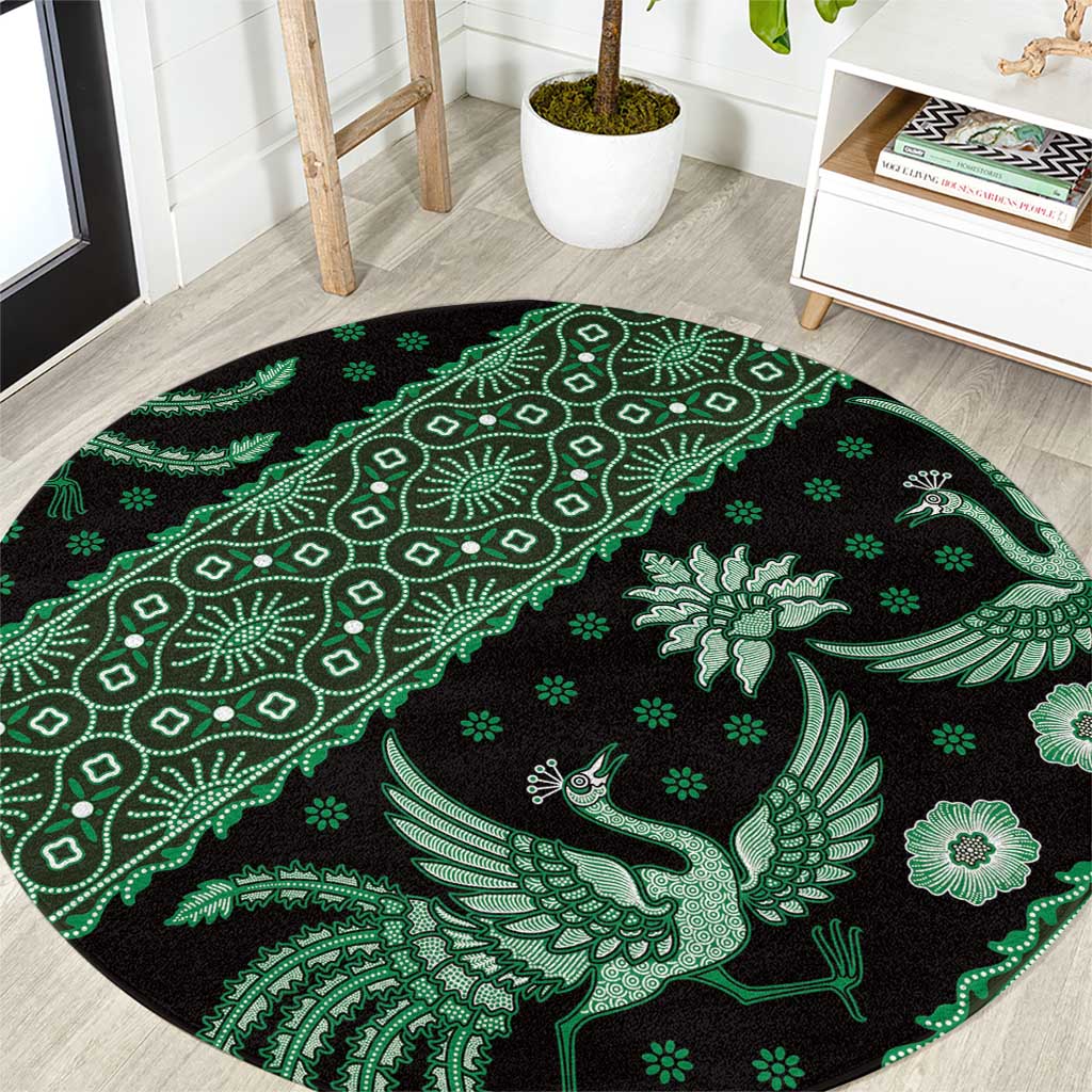 Round green and black batik-style carpet with bird and vine motifs