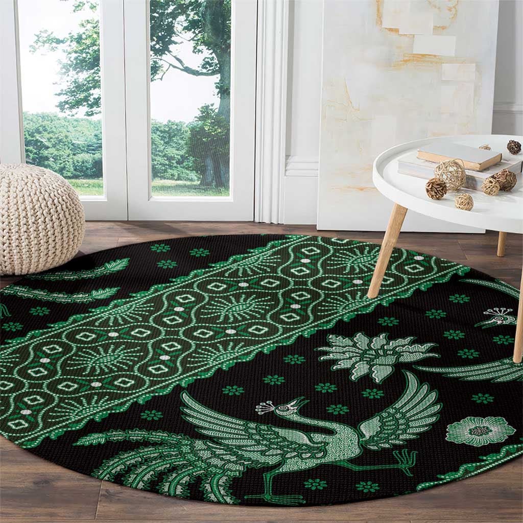 Round green and black batik-style carpet with bird, vine, and diamond motifs