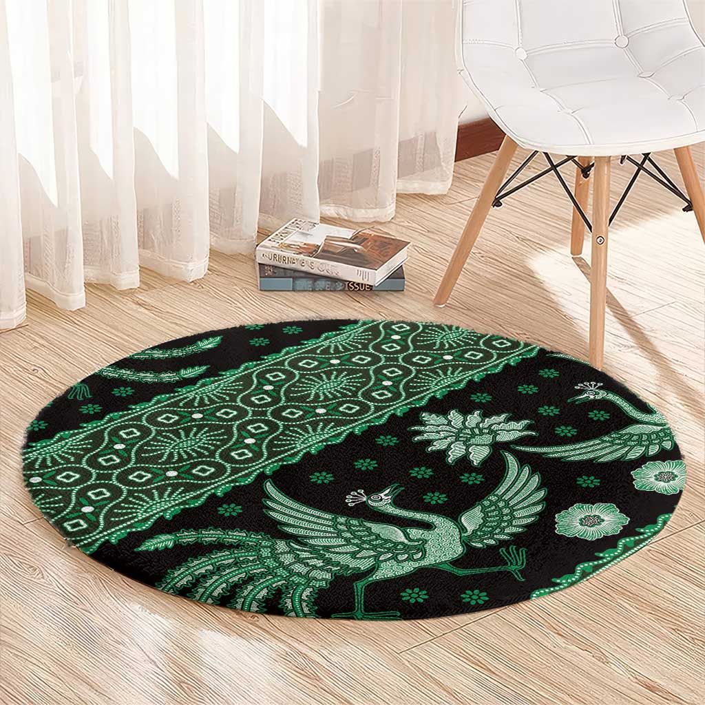 Round green and black batik-style rug with bird and geometric pattern band