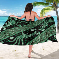 Green batik pattern sarong with white ornate motifs, draped from back