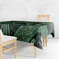 Green batik-pattern tablecloth draped over dining table with leafy geometric details