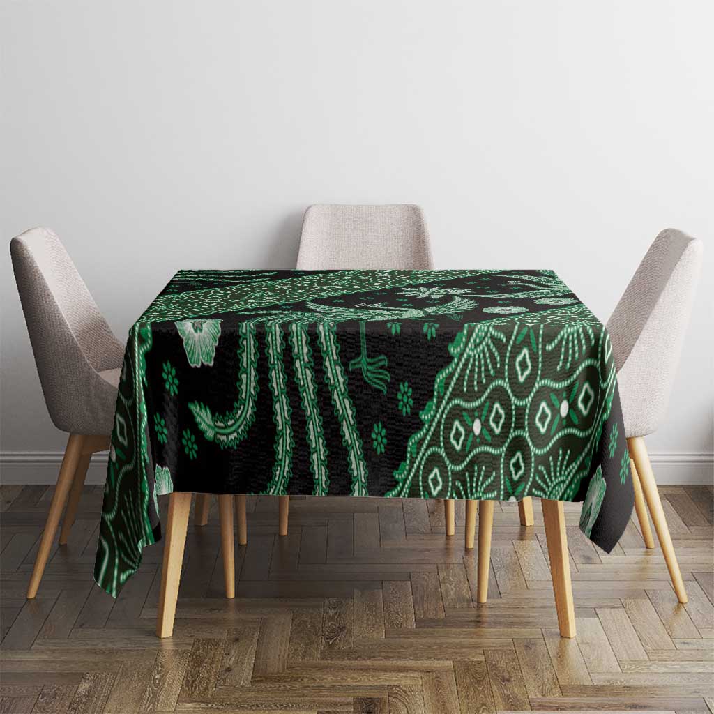 Green batik-pattern tablecloth on dining table, featuring geometric lines and bird motifs