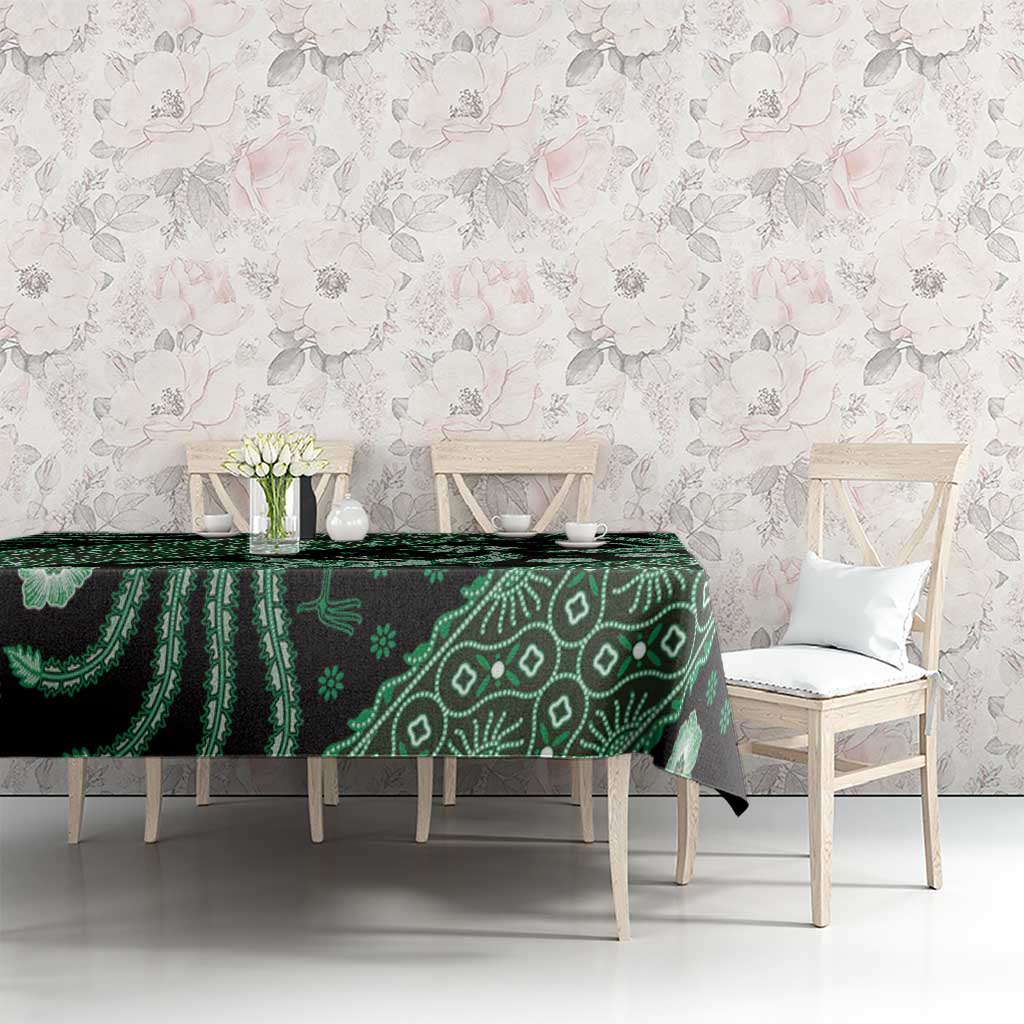 Green batik-pattern tablecloth on dining table with floral accents and bird motifs