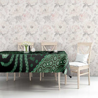 Green batik-pattern tablecloth on dining table with floral accents and bird motifs