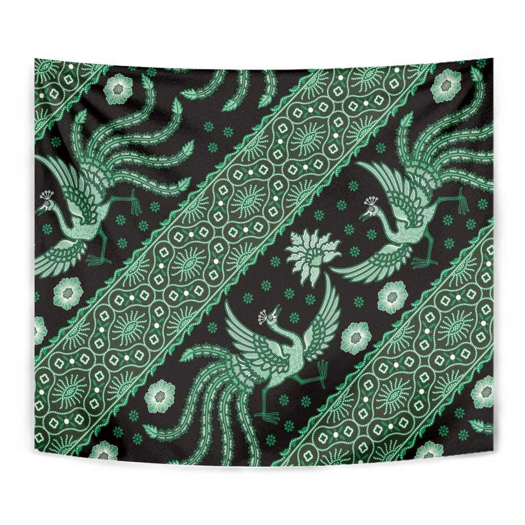 Green batik tapestry featuring repeating bird, flower, and geometric motifs on dark background.