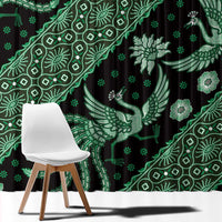 Green batik-pattern window curtain close-up with bird motifs and dotted accents on dark fabric
