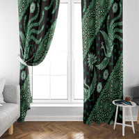 Green batik-pattern window curtain panels framing a white window, bird and floral motifs