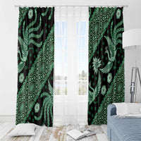 Green batik-pattern window curtain panels on a rod, bird and leaf motifs on dark fabric