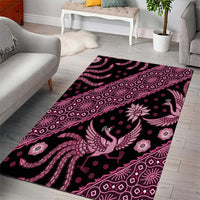 Magenta batik-pattern area rug featuring bird motif and paisley-like shapes on dark base