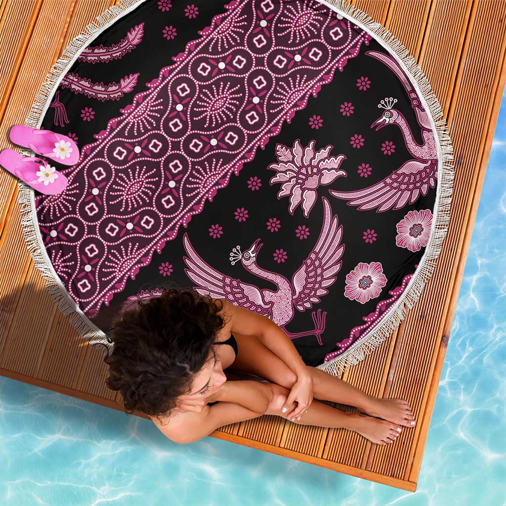 Round batik beach blanket, dark fabric with pink bird and floral pattern, fringed perimeter.