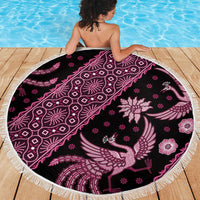 Round batik beach blanket with dark base, pink floral bird pattern, fringed edge.