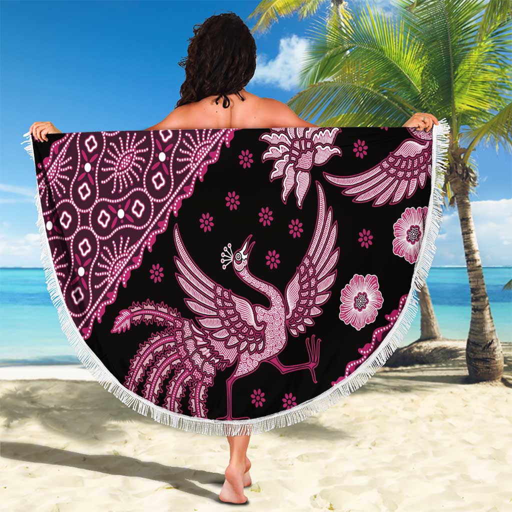 Round batik beach blanket, dark background with pink bird and floral medallion pattern, fringe.