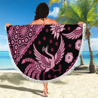 Round batik beach blanket, dark background with pink bird and floral medallion pattern, fringe.