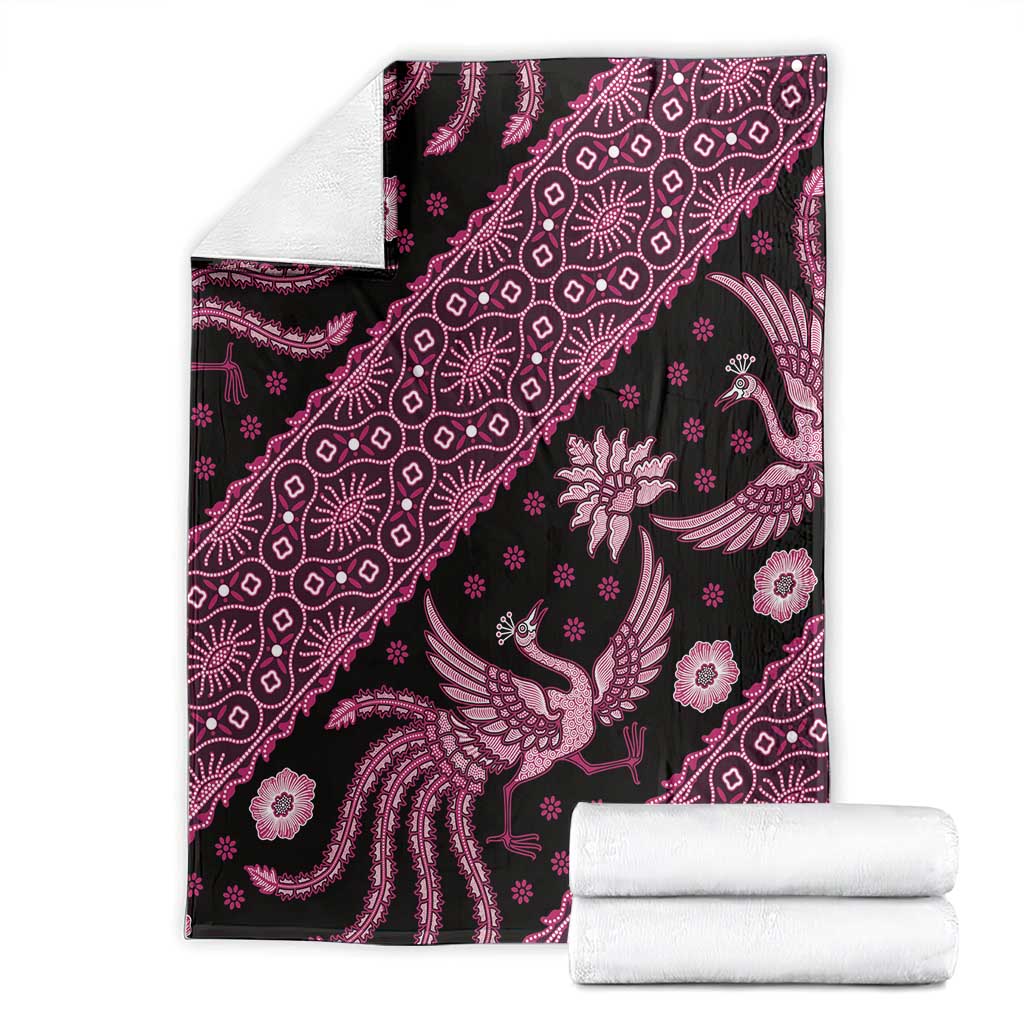 Pink and white batik pattern blanket with bird and floral motifs on dark fabric