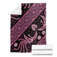 Pink and white batik pattern blanket with bird and floral motifs on dark fabric
