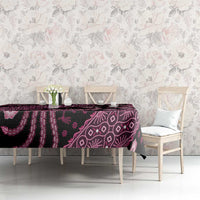 Batik tablecloth covering table, dark fabric with pink banded paisley and floral designs.
