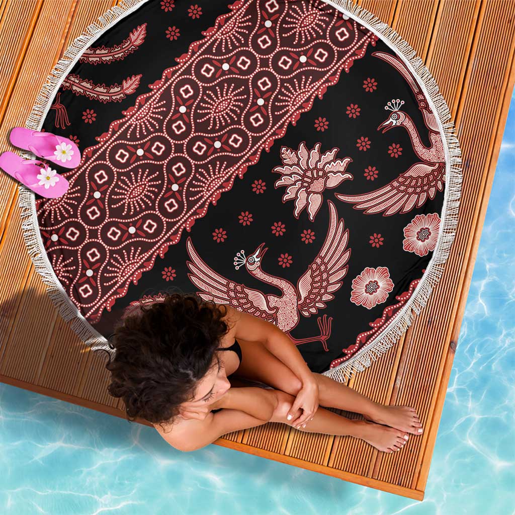 Round batik beach blanket with red floral and bird motifs on dark base, white fringe