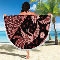 Round batik beach blanket with dark fabric, red bird motifs, and white fringe edging