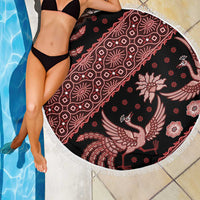 Round batik beach blanket with red bird and floral motifs on dark fabric, white tassel fringe