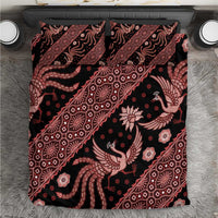 Batik bedding set in red and black with intricate bird and floral pattern, on bed
