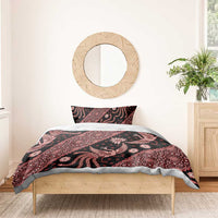 Batik bedding set with red-and-black patterned duvet and two pillowcases on wooden bed