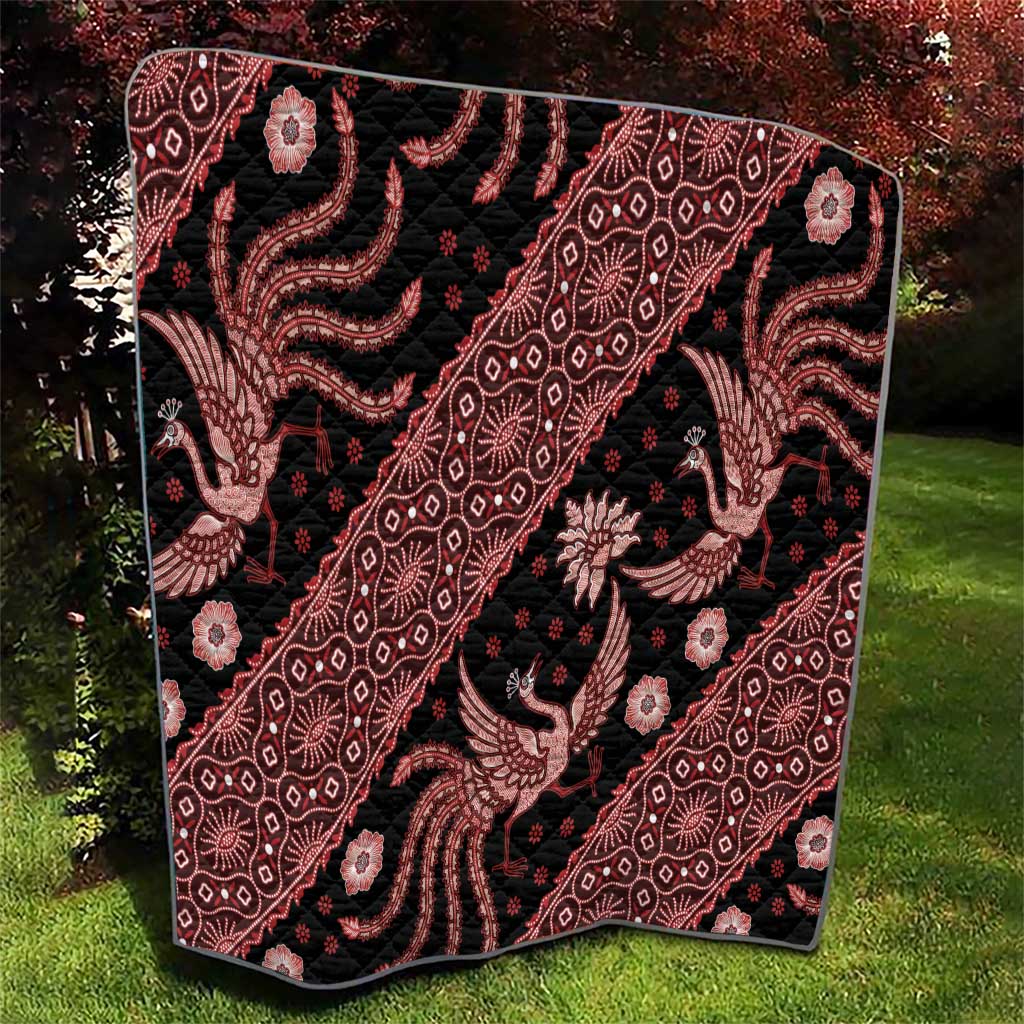Red and black batik pattern quilt with repeating geometric lines and animal figures