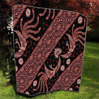 Red and black batik pattern quilt with repeating geometric lines and animal figures