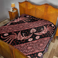 Red and black batik pattern quilt on a bed, featuring scrolling animal and floral designs