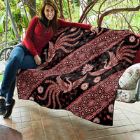 Red and black batik pattern quilt blanket with ornate decorative motifs, shown folded