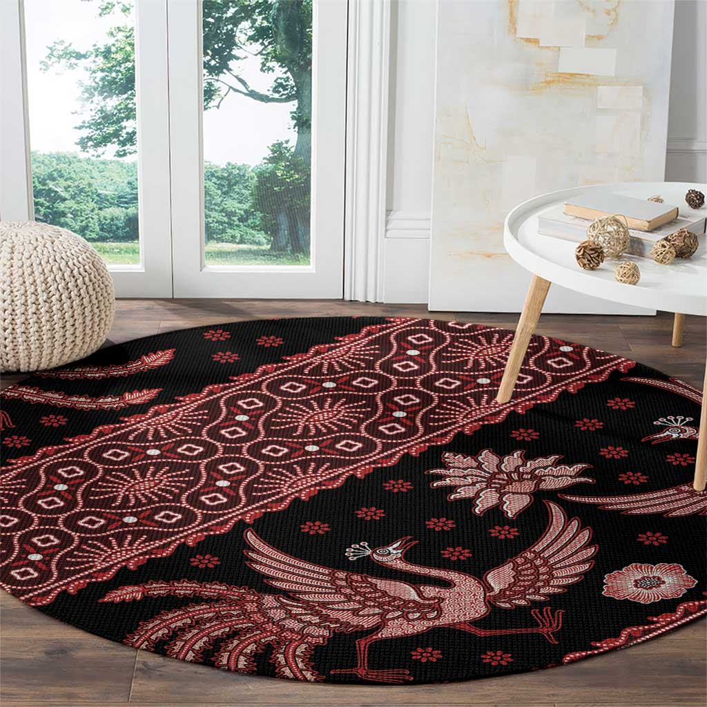 Round black batik carpet with red geometric pattern and bird-and-bloom motif