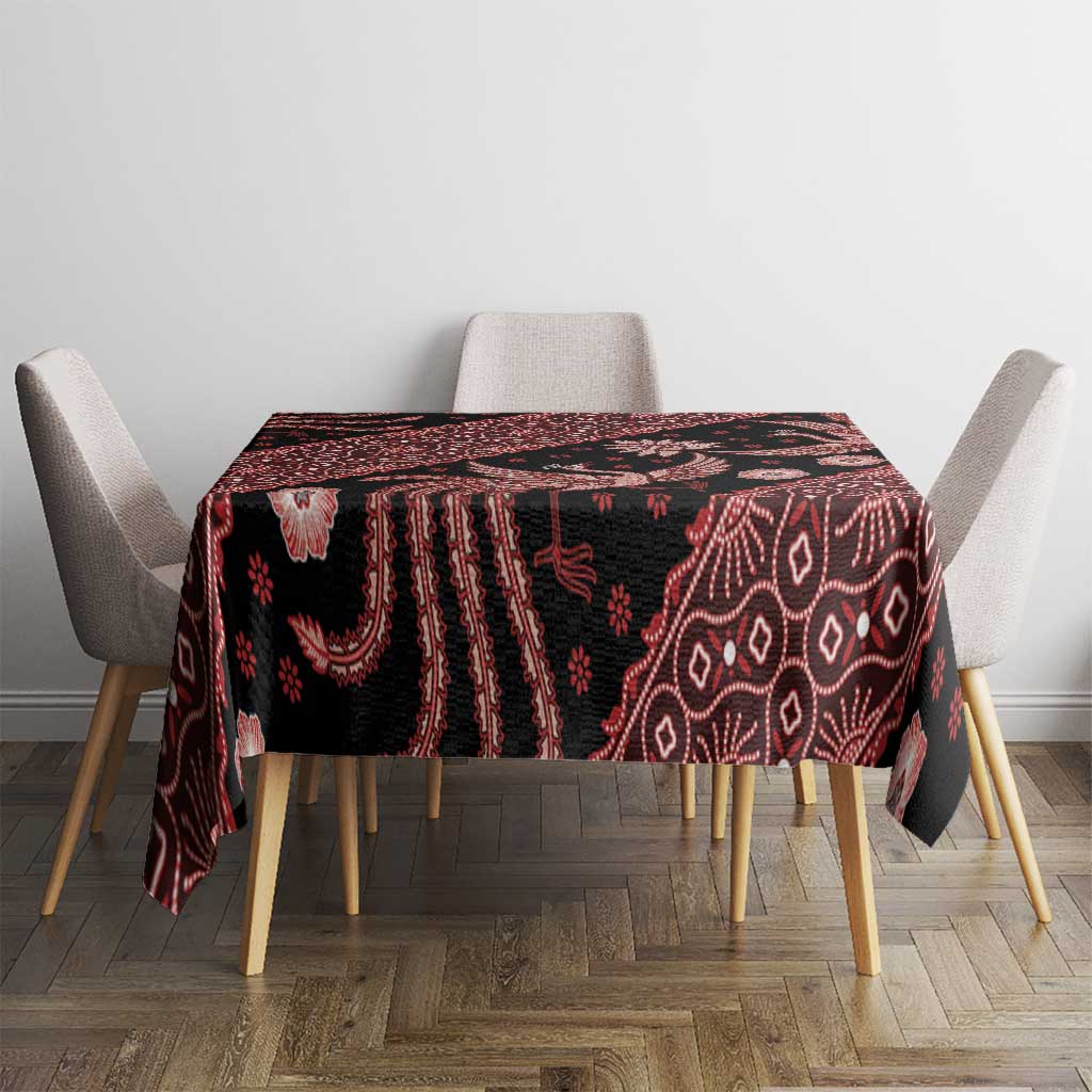 Red batik tablecloth covering table, dark base with batik birds, flowers, and geometric lines