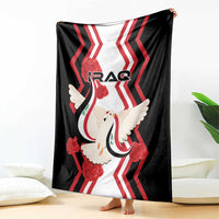 Black blanket draped outdoors-style, red zigzags and dove holding flag with IRAQ logo.
