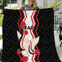 Black quilt laid out outdoors, showing “IRAQ” text, dove carrying flag, and red stripe design