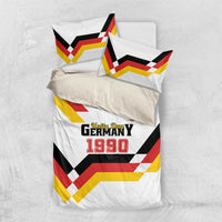 White bedding set from above with Unity Day 1990 print, shield logo, and red-yellow chevrons