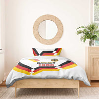 White bedding set with Unity Day 1990 text, shield emblem, and multicolor flag chevron